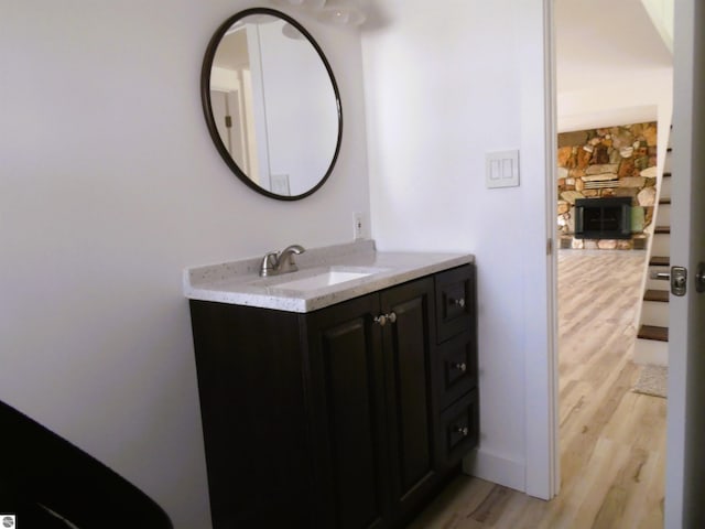 4177 Seminole St, Gladwin, MI 48624 - bathroom with wood finished floors, vanity, and a stone fireplace
