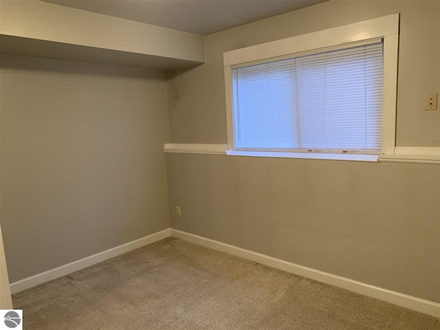 spare room with carpet and baseboards