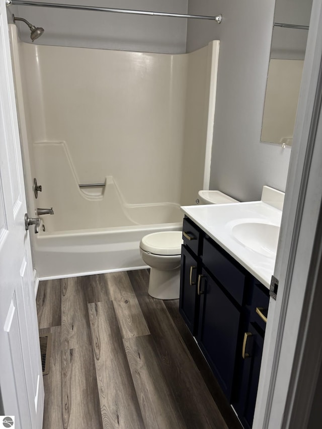 full bathroom featuring visible vents, toilet, shower / tub combination, wood finished floors, and vanity