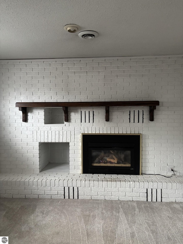 details with a fireplace, carpet, visible vents, and a textured ceiling