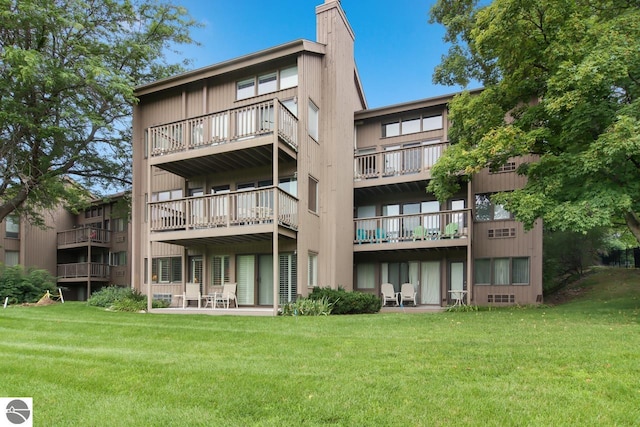 rear view of property with a lawn and a chimney