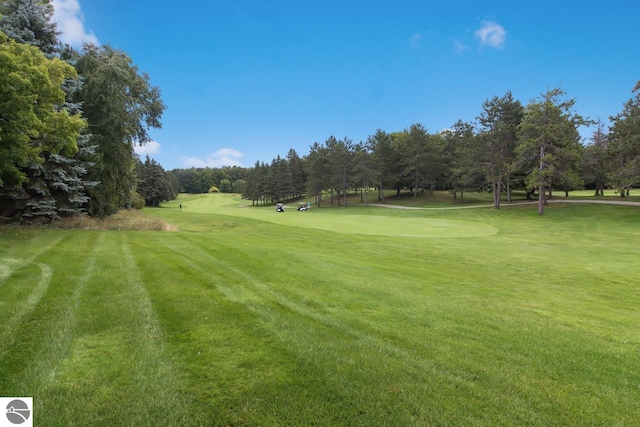 view of property's community with a yard and view of golf course