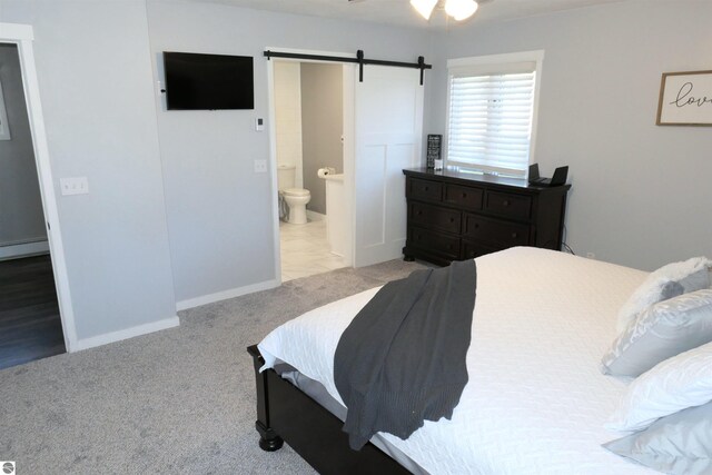 5661 Golfridge Rd, Alma, MI 48801 - carpeted bedroom with ensuite bath, baseboards, a baseboard heating unit, and a barn door