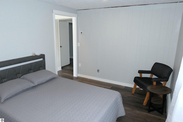 5661 Golfridge Rd, Alma, MI 48801 - bedroom featuring baseboards and dark wood-type flooring