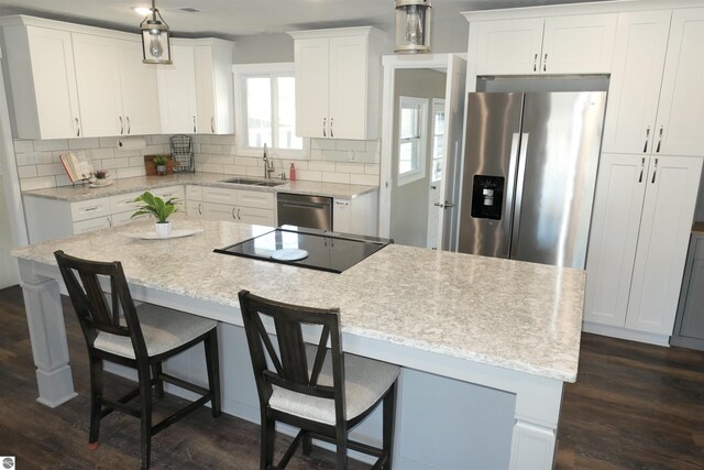 5661 Golfridge Rd, Alma, MI 48801 - kitchen featuring a sink, backsplash, a kitchen island, white cabinetry, and appliances with stainless steel finishes