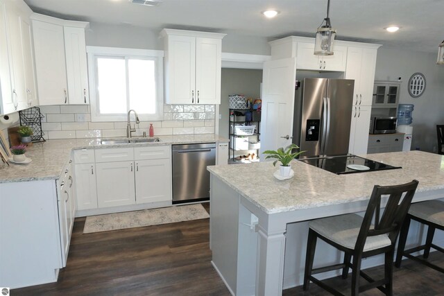 5661 Golfridge Rd, Alma, MI 48801 - kitchen featuring dark wood-style flooring, a sink, appliances with stainless steel finishes, white cabinetry, and backsplash