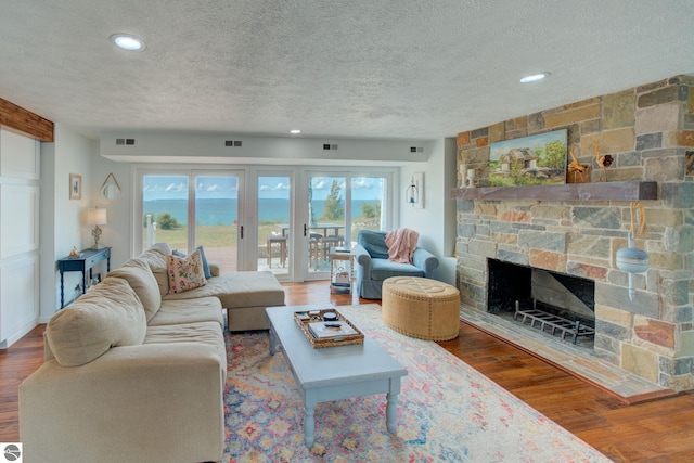 4781 E Golfview Dr, Leland, MI 49654 - living area featuring a textured ceiling, visible vents, and a fireplace