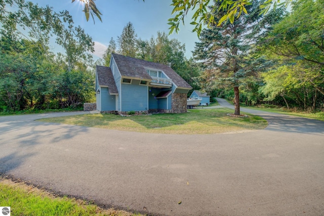4781 E Golfview Dr, Leland, MI 49654 - view of front of house with a front lawn and aphalt driveway