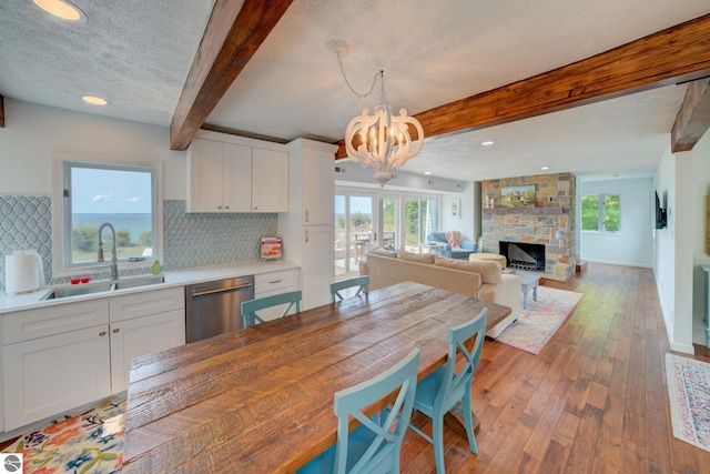 4781 E Golfview Dr, Leland, MI 49654 - dining area with a textured ceiling, an inviting chandelier, a wealth of natural light, wood-type flooring, and beam ceiling