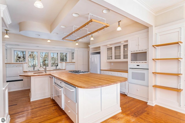 kitchen with white cabinetry, white appliances, light wood-type flooring, and butcher block counters