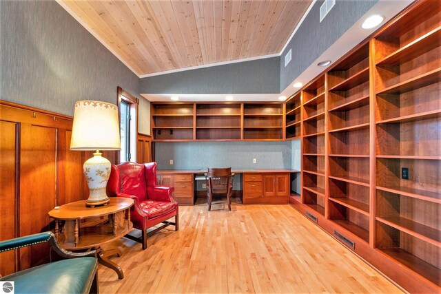 office space with crown molding, wood ceiling, vaulted ceiling, built in desk, and light wood-style floors