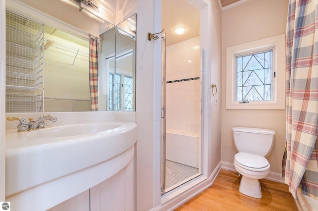 full bathroom featuring toilet, a shower stall, plenty of natural light, and wood finished floors