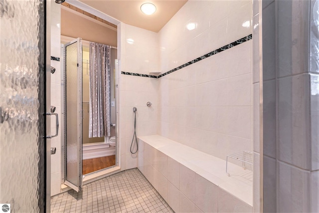 full bathroom with tile patterned floors, toilet, and a stall shower