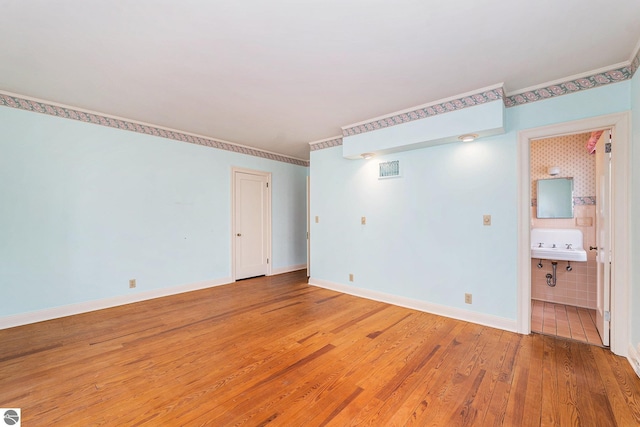 empty room with visible vents, baseboards, and light wood-style floors