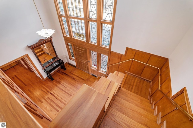 entryway with visible vents, wood finished floors, a notable chandelier, and a towering ceiling