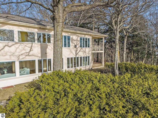 rear view of property featuring stucco siding and a balcony