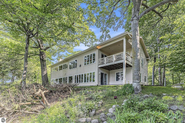 501 Michigan Ave, Frankfort, MI 49635 - back of house featuring a balcony and stucco siding
