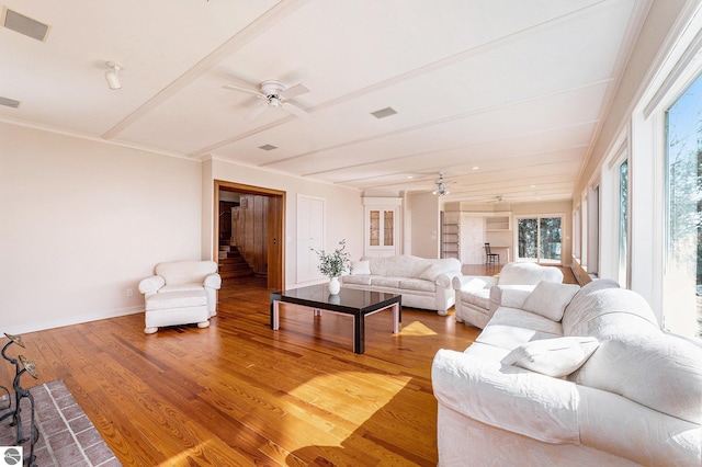 living room featuring light wood finished floors, visible vents, stairway, and a ceiling fan