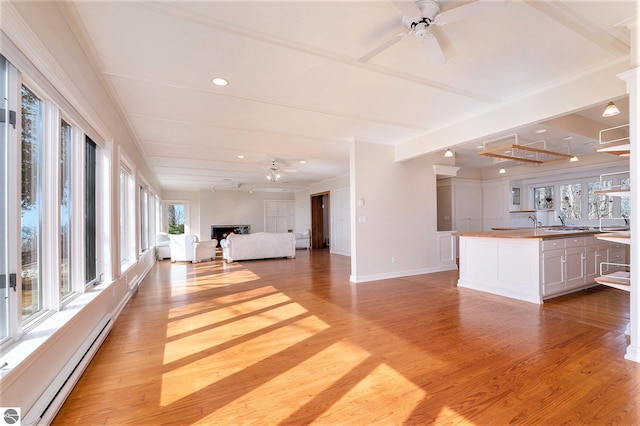 unfurnished living room featuring a fireplace, light wood finished floors, and ceiling fan