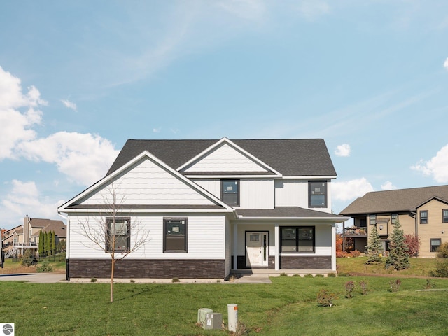 modern inspired farmhouse with a front yard and roof with shingles
