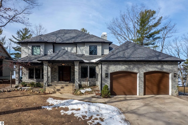 5568 Lakeview Dr, Interlochen, MI 49643 - view of front of property with a garage, a porch, concrete driveway, and a chimney