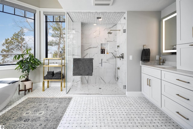 5568 Lakeview Dr, Interlochen, MI 49643 - bathroom with a marble finish shower, baseboards, vanity, and a freestanding bath