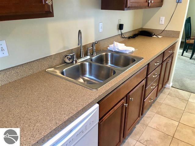 5525 Golfview Ct Unit 10, Williamsburg, MI 49690 - kitchen with light tile patterned flooring, white dishwasher, and a sink