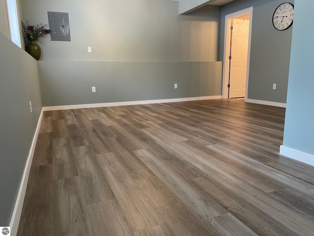 11893 Lillian Lee Dr, Interlochen, MI 49643 - unfurnished room featuring electric panel, wood finished floors, and baseboards
