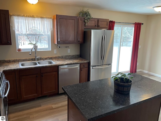 11893 Lillian Lee Dr, Interlochen, MI 49643 - kitchen with appliances with stainless steel finishes, a sink, plenty of natural light, and light wood-style floors