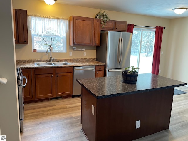 11893 Lillian Lee Dr, Interlochen, MI 49643 - kitchen with stainless steel appliances, a sink, light wood-type flooring, and dark countertops