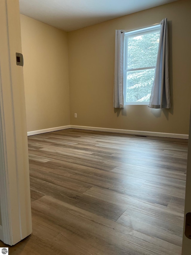 11893 Lillian Lee Dr, Interlochen, MI 49643 - unfurnished room featuring wood finished floors and baseboards