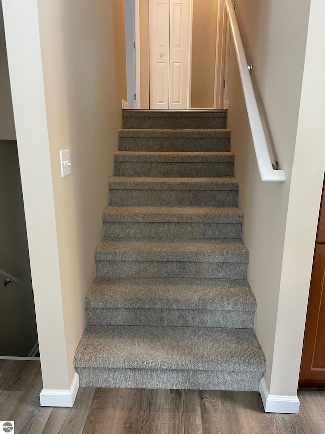 11893 Lillian Lee Dr, Interlochen, MI 49643 - stairs featuring wood finished floors and baseboards