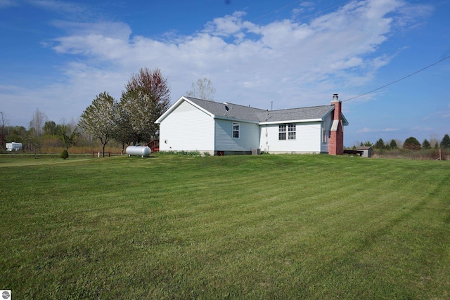 back of property featuring a yard and a chimney