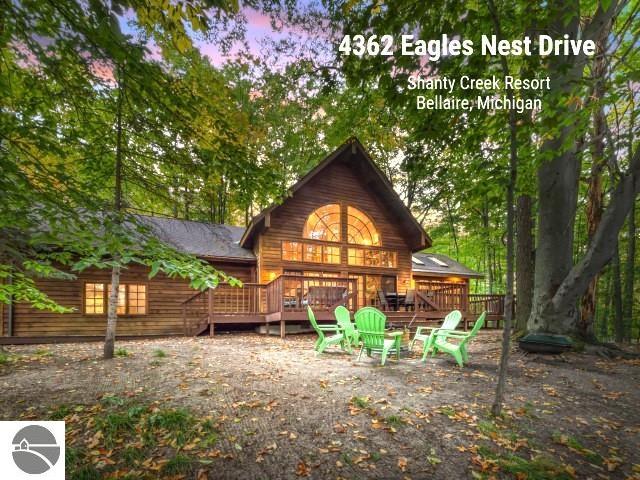 rear view of house featuring a deck and an outdoor fire pit