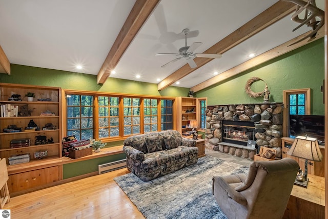 living room featuring lofted ceiling with beams, baseboard heating, a stone fireplace, a textured wall, and wood-type flooring