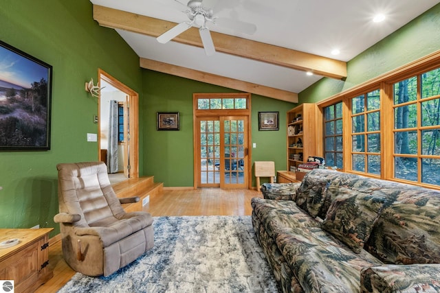 living room featuring vaulted ceiling with beams, baseboards, ceiling fan, french doors, and wood finished floors