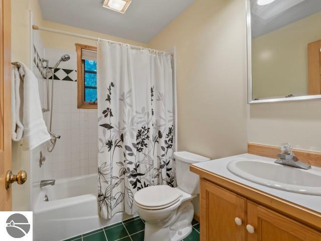 bathroom featuring visible vents, toilet, shower / tub combo, tile patterned floors, and vanity