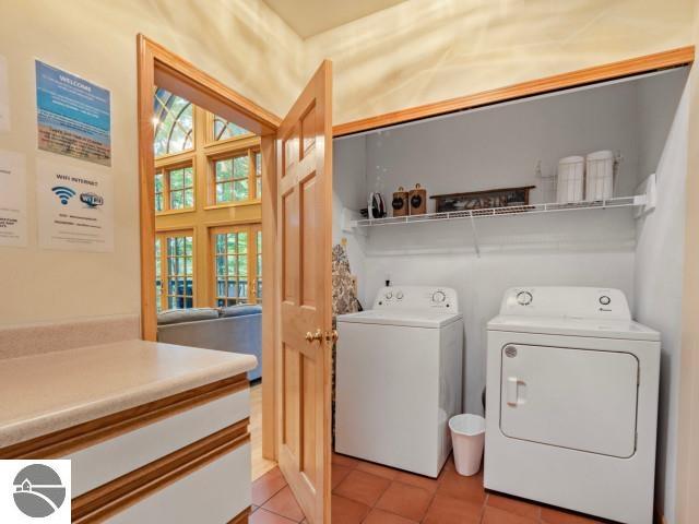 laundry room featuring light tile patterned floors, laundry area, and separate washer and dryer