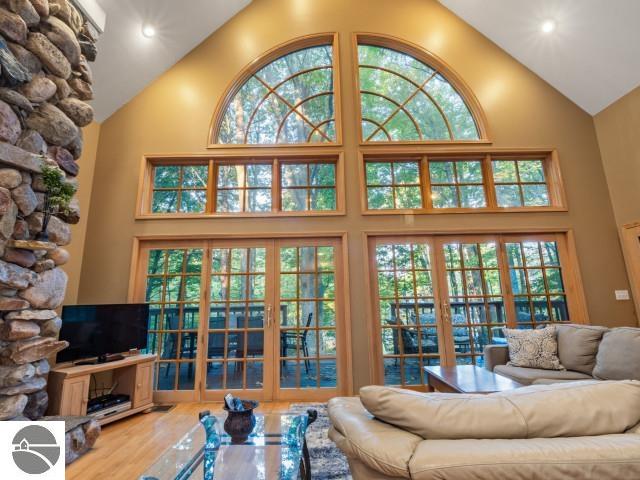 living room featuring plenty of natural light, high vaulted ceiling, and wood finished floors