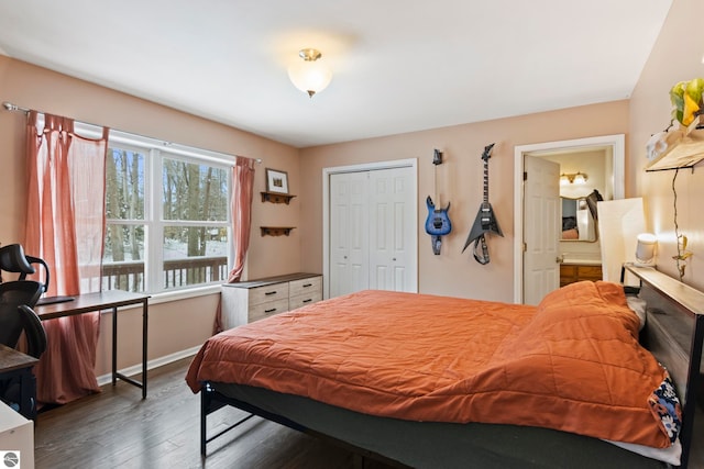 bedroom featuring dark wood-type flooring, baseboards, a closet, and connected bathroom