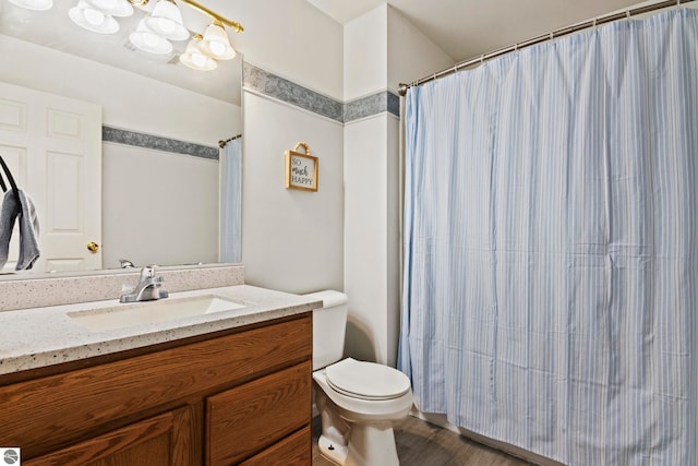 bathroom with vanity, a shower with curtain, toilet, and wood finished floors