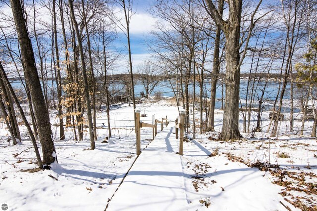 yard layered in snow featuring a water view