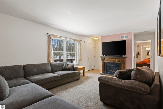 carpeted living room with visible vents and a fireplace
