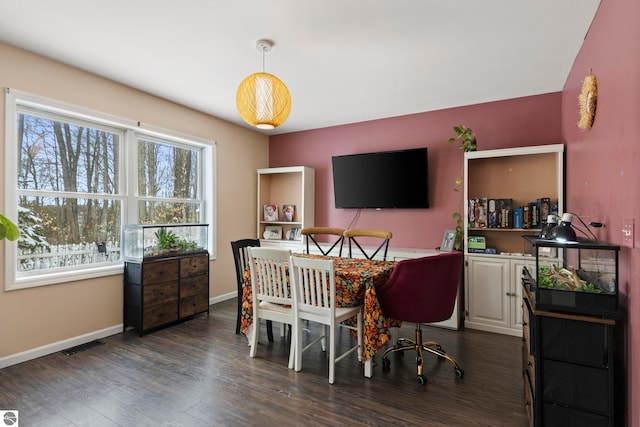 dining room featuring dark wood-type flooring and baseboards