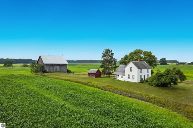 view of yard with an outbuilding, a rural view, and a barn