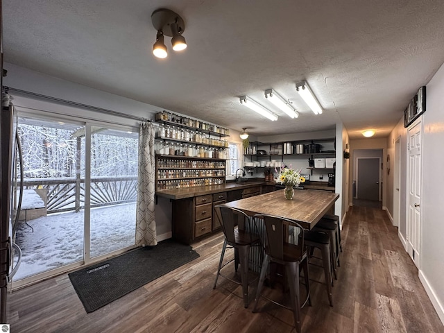 dining area featuring dark wood-style floors, baseboards, and a textured ceiling