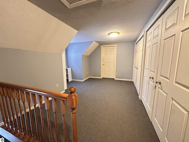bonus room featuring baseboards, a textured ceiling, vaulted ceiling, and dark colored carpet