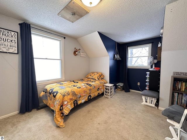 bedroom featuring baseboards, vaulted ceiling, carpet flooring, and a textured ceiling