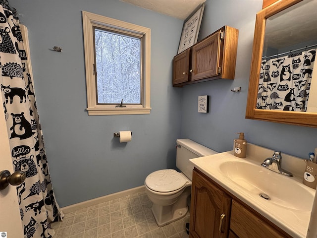 bathroom with a shower with curtain, toilet, vanity, and baseboards