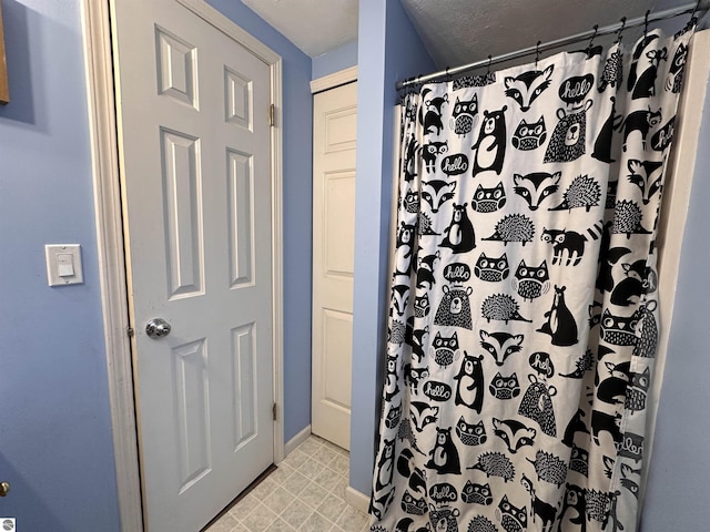 bathroom featuring baseboards and curtained shower